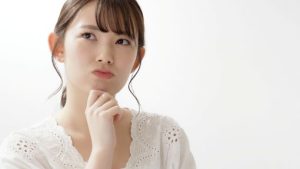 顎に手を当てて悩む女性