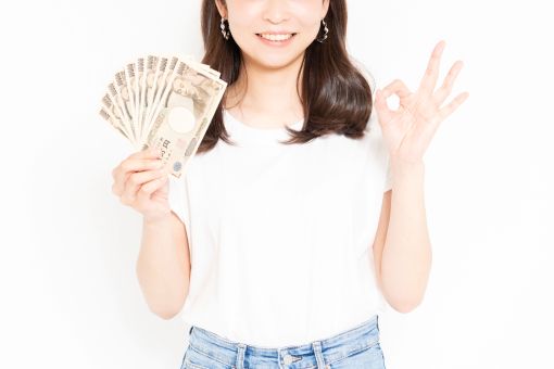 お札とOKサインをする女性