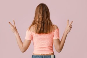ピースする後ろ姿の女性